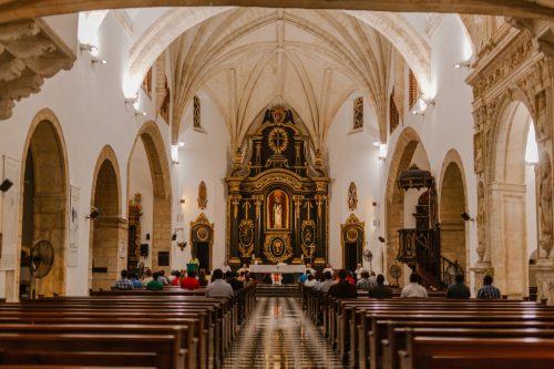 unrecognizable prayers on pews during mass in catholic cathedral