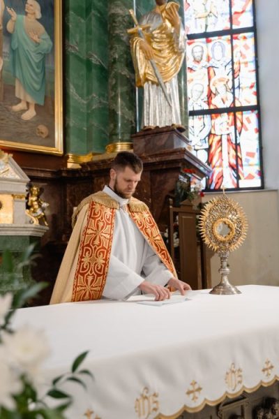 man in white and red robe sitting on chair