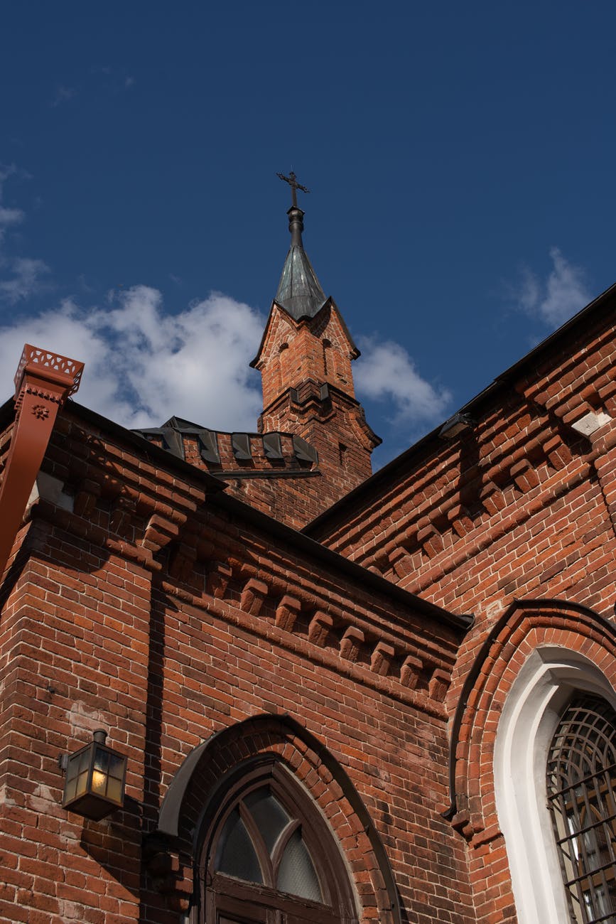 brown brick church under blue sky