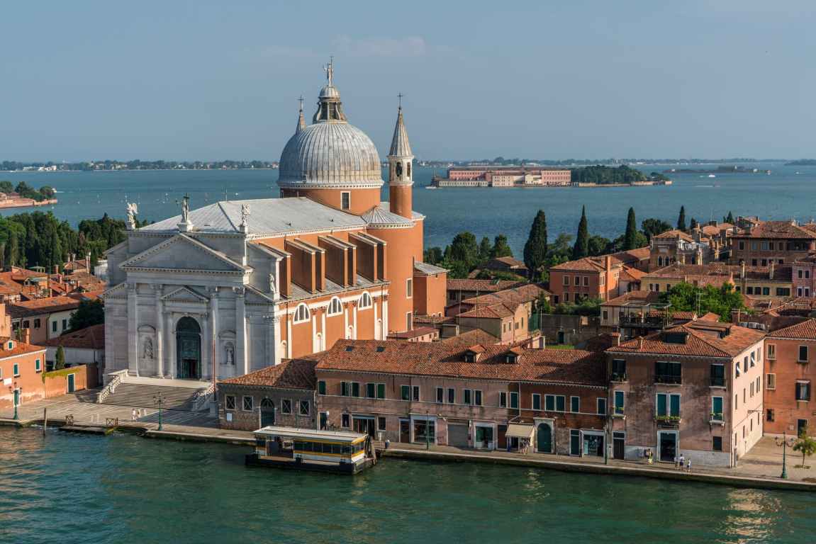 white and beige structure building and cathedral near body of water during daytime