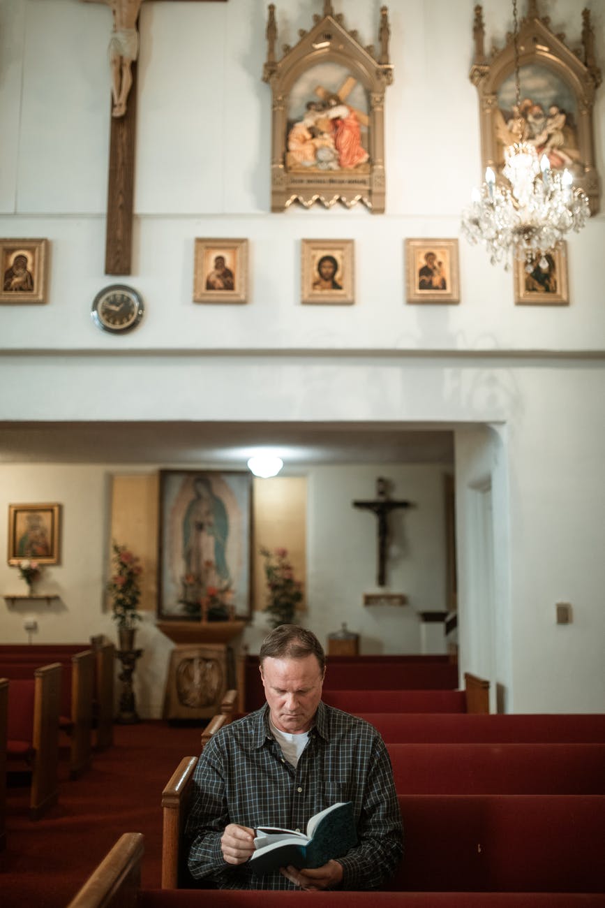man in black and white checkered dress shirt sitting on red chair