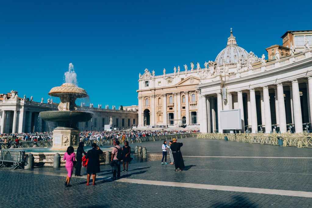 white building and people standing near water fountain